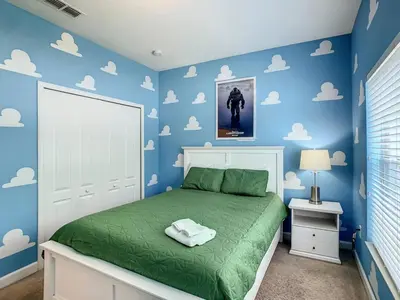 a bedroom with a bed with blue walls and clouds at Storey Lake Dreamy Townhome, 5 mi Disney Universal in Kissimmee