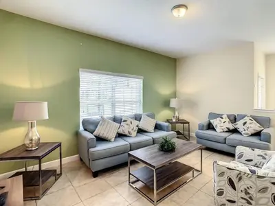 a living room with a couch and a table at Storey Lake Dreamy Townhome, 5 mi Disney Universal in Kissimmee