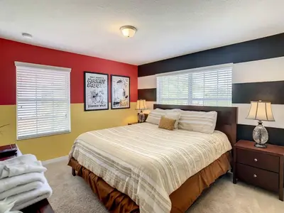 a bedroom with a bed with red and yellow walls at Storey Lake Dreamy Townhome, 5 mi Disney Universal in Kissimmee
