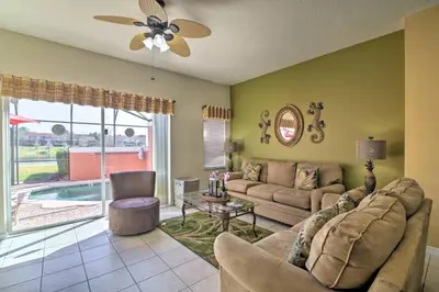 a living room with a couch and a table at Enchanted Jungle Themed Home Pool 3mi to Disney in Kissimmee