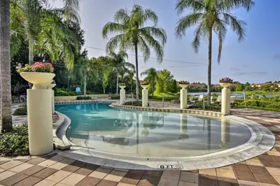 a swimming pool with palm trees in the background at Enchanted Jungle Themed Home Pool 3mi to Disney in Kissimmee