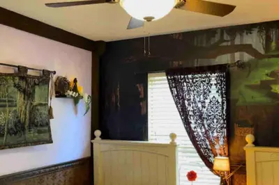 a living room with a ceiling fan and a window at Enchanted Jungle Themed Home Pool 3mi to Disney in Kissimmee