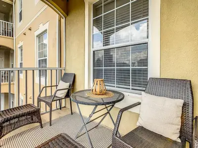 a balcony with a table and chairs and a window at Windsor Hills Mickey Mouse Condo, 2.5mi Disney in Orlando