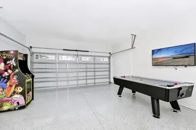 a room with a pool table and a video game at Stylish Home With Private Pool, Themed And Game Room With Waterpark & Resort Access Near Disney At Encore Resorts Reunion - 300Bu in Kissimmee