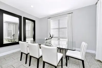 a dining room with a glass table and white chairs at Stylish Home With Private Pool, Themed And Game Room With Waterpark & Resort Access Near Disney At Encore Resorts Reunion - 300Bu in Kissimmee