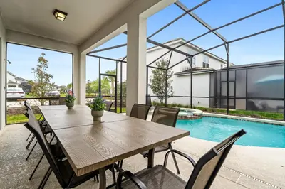 a dining room with a table and chairs and a swimming pool at Big Family Home with Game Room Sleeps 28 BLV104 in Kissimmee