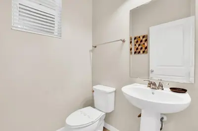 a white bathroom with a toilet and a sink at Comfy House at Compass Bay CB102 in Kissimmee