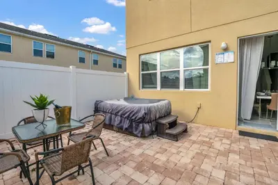 a patio with a table and chairs and a table and a building at Comfy House at Compass Bay CB102 in Kissimmee