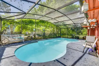 a swimming pool in a greenhouse with a chair at Orlando-Area Family Oasis with Lanai, Pool and Yard in Orlando