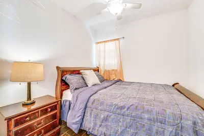 a bedroom with a bed and a lamp on a dresser at Orlando-Area Family Oasis with Lanai, Pool and Yard in Orlando