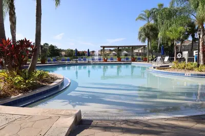 a large swimming pool with palm trees in a resort at UniDisL 3Br3B near Disney quiet resort community, pool, private hot tub, BBQ & games in Kissimmee