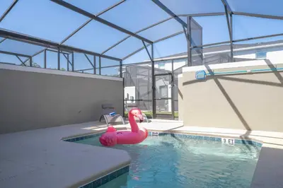 a swimming pool with a pink swan in the water at 4Bd Close to Disney with Pool at Storey Lake 2560 in Kissimmee