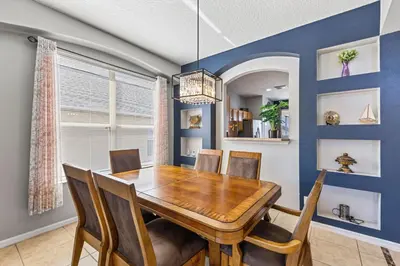 a dining room with a wooden table and chairs at 7BDM Prvt Pool Villa - Gated Resort 10min to Disney in Kissimmee