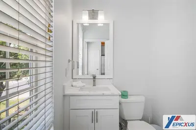 a white bathroom with a sink and a mirror at The Epic Toronto Vista Cay Orlando in Orlando