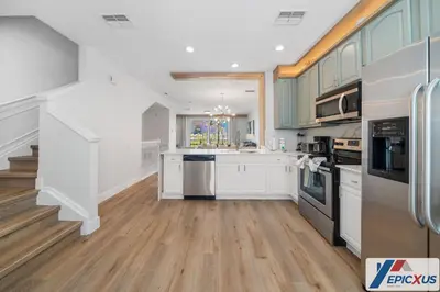 a kitchen with white cabinets and wooden floors at The Epic Toronto Vista Cay Orlando in Orlando