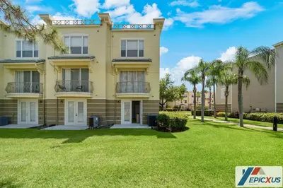 a large yellow house with palm trees in front of it at The Epic Toronto Vista Cay Orlando in Orlando