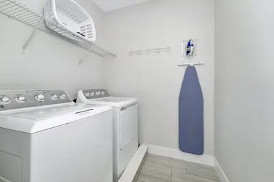 a laundry room with a washing machine and a blue tie at Elegant Home Near Disney With Game & Themed Rooms With Waterpark & Resort Access At Encore Resorts Reunion - 400La in Kissimmee