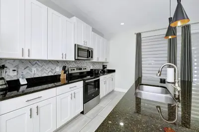 a kitchen with white cabinets and a sink at Elegant Home Near Disney With Game & Themed Rooms With Waterpark & Resort Access At Encore Resorts Reunion - 400La in Kissimmee