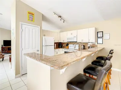 a kitchen with a counter with a sink and a refrigerator at Private Pool With Heat - Close to Disney! in Kissimmee