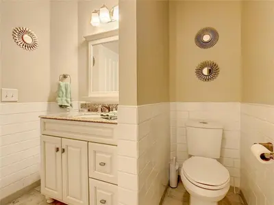 a bathroom with a toilet and a sink and mirrors at Private Pool With Heat - Close to Disney! in Kissimmee