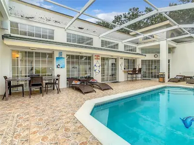 a swimming pool in a patio with a table and chairs at Private Pool With Heat - Close to Disney! in Kissimmee