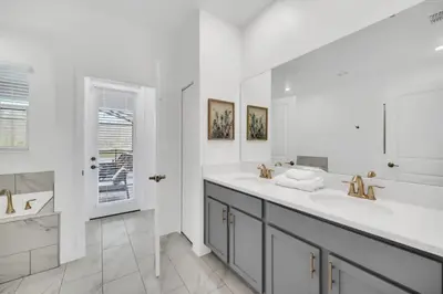 a white bathroom with two sinks and a large mirror at Amazing 9 Bedroom Lake View in Kissimmee