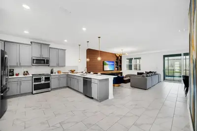 an open kitchen and living room with a couch at Amazing 9 Bedroom Lake View in Kissimmee