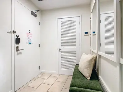 a bathroom with white walls and a green couch at 1Bed/1Bath Pet Friendly Condo at the Melia in Orlando