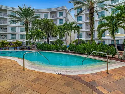 a swimming pool in front of a building with palm trees at 1Bed/1Bath Pet Friendly Condo at the Melia in Orlando