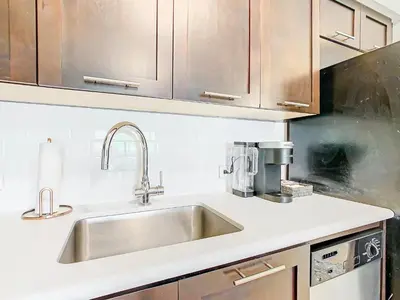a kitchen with a stainless steel sink and wooden cabinets at 1Bed/1Bath Pet Friendly Condo at the Melia in Orlando