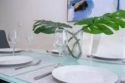 a table with plates and glasses and a potted plant at Amazing 2024 Villa 5 min to Disney in Orlando