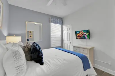 a bedroom with a white bed and a television at 8131 Sun Palm in Kissimmee