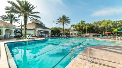a swimming pool at a resort with palm trees at 8131 Sun Palm in Kissimmee