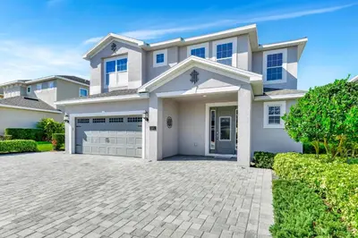 a large white house with a driveway at Lavish Home Near Disney With Media, Game & Theme Rooms With Waterpark & Resort Access At Encore Resorts Reunion - 520Bu in Kissimmee