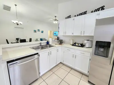 a white kitchen with a sink and a dishwasher at Home Close to Disney Parks/Amazing Private Pool in Orlando