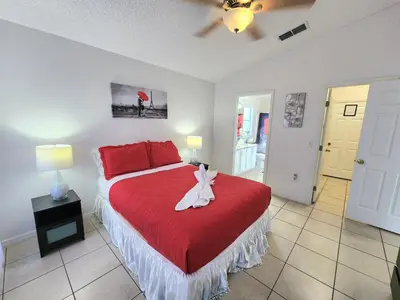 a bedroom with a red bed with a red blanket at Home Close to Disney Parks/Amazing Private Pool in Orlando