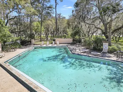 an empty swimming pool with trees in the background at 7832 Cozy Gem at Indian Ridge with Pool in Orlando