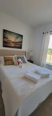 a large white bed with two towels on it at Resort-Style Home in gated community with ammenities close to MCO and Parks! in Kissimmee