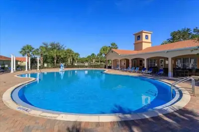 a large pool in front of a resort building at Resort-Style Home in gated community with ammenities close to MCO and Parks! in Kissimmee