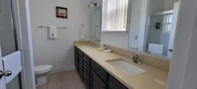 a bathroom with a sink and a toilet and a mirror at Resort-Style Home in gated community with ammenities close to MCO and Parks! in Kissimmee