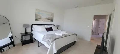 a white bedroom with a bed and a mirror at Resort-Style Home in gated community with ammenities close to MCO and Parks! in Kissimmee