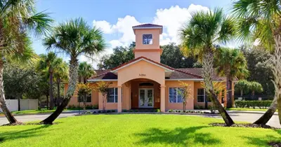 a home with palm trees in front of it at Resort-Style Home in gated community with ammenities close to MCO and Parks! in Kissimmee
