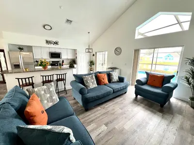 a living room with two blue couches and a kitchen at Buena Ventura Escape in Kissimmee