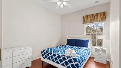 a bedroom with a bed with blue sheets and a ceiling fan at Shvck3 - Coral Cay Resort #3 - 4 Bed 3 Baths Townhome in Kissimmee