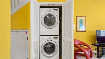 two washing machines in a room with a red chair at Shvck3 - Coral Cay Resort #3 - 4 Bed 3 Baths Townhome in Kissimmee