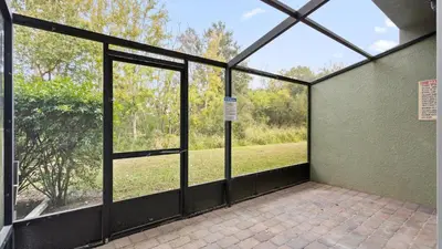 a screened in porch with a view of a field at Shvck4 - Coral Cay Resort #4 - 4 Bed 3 Baths Townhome in Kissimmee
