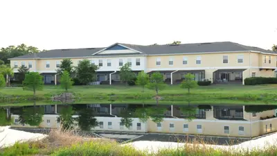 a large white building with a reflection in the water at Shvck4 - Coral Cay Resort #4 - 4 Bed 3 Baths Townhome in Kissimmee