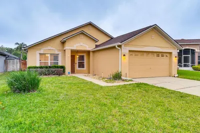a house with a driveway and a garage at Lovely Florida Retreat with Lanai 5 Mi to Riverwalk in Lake Mary