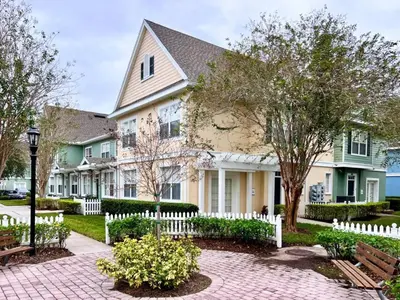 a large house with a white picket fence at Lovely Family Town home in Great Location townhouse in Kissimmee