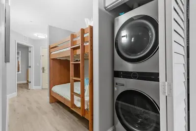 a room with a washing machine and a bunk bed at Scenic View Condo Near Disney in Orlando